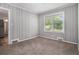 Cozy bedroom featuring wood paneled walls, plush carpet, and a window offering a view of the outdoors at 1879 Rosewood Rd, Decatur, GA 30032