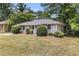 View of a charming single-story house with a neatly kept lawn and mature trees surrounding the property at 1879 Rosewood Rd, Decatur, GA 30032