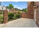 Brick-walled patio with an iron fence and access to townhomes beyond at 27 Jefferson Hill Ne Pl, Atlanta, GA 30342