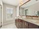 Bathroom with a large mirror, double sinks, granite countertops, and window with plantation shutters at 27 Jefferson Hill Ne Pl, Atlanta, GA 30342