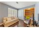 Bedroom with a small sofa, a built-in desk, wood floors, plantation shutters and a modern ceiling fan at 27 Jefferson Hill Ne Pl, Atlanta, GA 30342