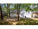 Backyard view of freshly painted home with level lawn, mature trees and stone ground cover at 8420 Sheridan Dr, Jonesboro, GA 30236