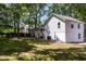 Backyard view of two-story home with level lawn, mature trees, stone ground cover, and patio at 8420 Sheridan Dr, Jonesboro, GA 30236