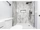 Bathroom featuring white marble walk-in shower with black shower head and built in niche at 8420 Sheridan Dr, Jonesboro, GA 30236