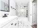 Modern bathroom with marble-style tiling, black fixtures, a shower-tub, and a white vanity at 8420 Sheridan Dr, Jonesboro, GA 30236
