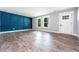 Bright living room featuring a bold accent wall, hardwood floors, and a white front door at 8420 Sheridan Dr, Jonesboro, GA 30236