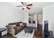 Comfortable living room featuring a ceiling fan, plush sofa, and stylish ottoman on dark hardwood floors at 10 Perimeter Summit Ne Blvd # 4243, Brookhaven, GA 30319