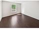 Cozy bedroom with rich hardwood flooring, natural light streaming through the window, and neutral paint for personalization at 145 Shadowbrook Trce, Covington, GA 30016