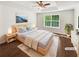Staged bedroom featuring a ceiling fan, large window and hardwood floors at 145 Shadowbrook Trce, Covington, GA 30016