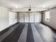Spacious two-car garage featuring a modern door, ample lighting, and durable floor covering with gray and black stripes at 145 Shadowbrook Trce, Covington, GA 30016