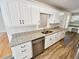 Renovated kitchen with granite countertops, stainless steel dishwasher and white cabinetry at 145 Shadowbrook Trce, Covington, GA 30016
