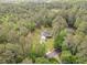 An aerial view showcasing a property surrounded by lush trees and a driveway at 2180 Briarwood Ct, Villa Rica, GA 30180