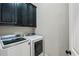 Modern laundry room featuring front-load washer and dryer with dark cabinets for storage at 3113 Lenox Ne Rd # 6, Atlanta, GA 30324
