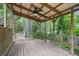 Large covered back deck with wooden railings offers plenty of room to enjoy the peaceful backyard at 2384 Shadowood Sw Dr, Conyers, GA 30094