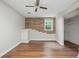 Bedroom featuring wood-look floors, a brick accent wall and a closet at 2384 Shadowood Sw Dr, Conyers, GA 30094