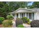 A well-maintained ranch-style house with white siding, green shutters, and a meticulously landscaped front yard at 2384 Shadowood Sw Dr, Conyers, GA 30094