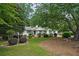 Charming single-story home with a well-manicured lawn, lush greenery, and mature trees providing shade at 2384 Shadowood Sw Dr, Conyers, GA 30094