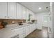 Well-lit kitchen featuring white cabinets, tiled backsplash, and stainless steel appliances for a modern touch at 2384 Shadowood Sw Dr, Conyers, GA 30094