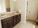 Bathroom featuring double sinks, dark wood cabinets, and a linen closet at 258 Creek View Ln, Acworth, GA 30102