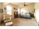 Bright primary bedroom featuring a ceiling fan, sitting area, and comfortable rocking chair at 258 Creek View Ln, Acworth, GA 30102