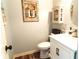 Charming powder room with wood look flooring, white vanity, and decorative wall art at 258 Creek View Ln, Acworth, GA 30102