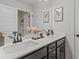 Bathroom featuring double sink vanity with black fixtures and white countertop with picture frame decor at 2700 Westgate Park Dr, Loganville, GA 30052