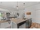 Kitchen island with granite counters opens to the living room with a fireplace and coffered ceilings at 2700 Westgate Park Dr, Loganville, GA 30052