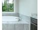 Beautiful bathroom with soaking tub under window and granite vanity at 3018 Old Covington Rd, Covington, GA 30014