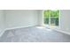Bright bedroom features neutral carpeting, a large window, and ample natural light at 3018 Old Covington Rd, Covington, GA 30014