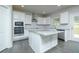 Modern kitchen with white cabinets, granite countertops, stainless steel appliances, and kitchen island at 3018 Old Covington Rd, Covington, GA 30014
