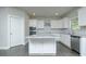 Modern kitchen featuring white cabinets, granite counters, stainless appliances, and gray hardwood flooring at 3018 Old Covington Rd, Covington, GA 30014