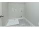 Compact laundry area with gray tile floor and connections for a washer and dryer at 3018 Old Covington Rd, Covington, GA 30014