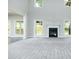 Open-concept living room with a fireplace, large windows, and neutral carpet at 3018 Old Covington Rd, Covington, GA 30014