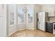 Bright breakfast nook with large windows, stylish chandelier, stainless steel refrigerator, and wood flooring at 103 Timber Ridge Dr, Cartersville, GA 30121
