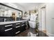 Modern bathroom featuring dual sinks, a soaking tub, black marble tile, and decorative shelving at 128 Graybrook Ct, Grayson, GA 30017