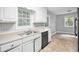 View of kitchen with dishwasher, white cabinets and view into attached living space at 155 S South Meadowcliff Cir, Carrollton, GA 30116