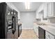 Galley kitchen with white cabinets, black appliances, and neutral countertops at 155 S South Meadowcliff Cir, Carrollton, GA 30116