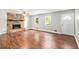 Spacious living room with hardwood floors, a ceiling fan, a stone fireplace, and plenty of natural light at 155 S South Meadowcliff Cir, Carrollton, GA 30116