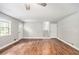 Inviting living room featuring beautiful hardwood floors, a ceiling fan, and abundant natural light from multiple windows at 155 S South Meadowcliff Cir, Carrollton, GA 30116