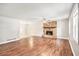 Spacious living room featuring hardwood floors, a stone fireplace, a ceiling fan, and lots of natural light at 155 S South Meadowcliff Cir, Carrollton, GA 30116