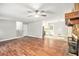 Spacious living room flowing into the kitchen, featuring hardwood floors, a ceiling fan, and a stone fireplace at 155 S South Meadowcliff Cir, Carrollton, GA 30116