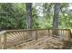 Wood deck surrounded by lush greenery, perfect for outdoor relaxation and entertainment at 23 Club Dr, Locust Grove, GA 30248