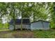 Backyard view featuring a home with a small deck, and lush trees in the distance at 23 Club Dr, Locust Grove, GA 30248