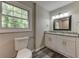 Bathroom with a granite double vanity, modern fixtures, and wood-look flooring at 23 Club Dr, Locust Grove, GA 30248