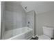 Bathroom featuring a tub with gray tiled walls and a toilet at 23 Club Dr, Locust Grove, GA 30248