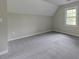 Bright bedroom features plush gray carpet and a window at 23 Club Dr, Locust Grove, GA 30248