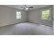 This bedroom has carpet, neutral walls, large windows, and great natural light at 23 Club Dr, Locust Grove, GA 30248