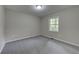 Cozy bedroom featuring neutral walls, carpet, and natural light from a window at 23 Club Dr, Locust Grove, GA 30248