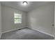 Cozy bedroom featuring neutral walls, carpet, and natural light from a window at 23 Club Dr, Locust Grove, GA 30248