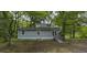 Exterior view of a gray home surrounded by green trees at 23 Club Dr, Locust Grove, GA 30248